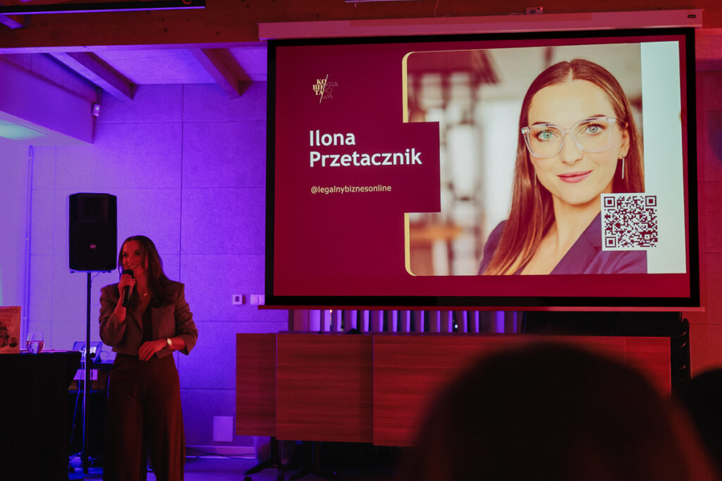 Prezentacja na tle ekranu multimedialnego. Ilona Przetacznik prezentuje Power Speech o AI 